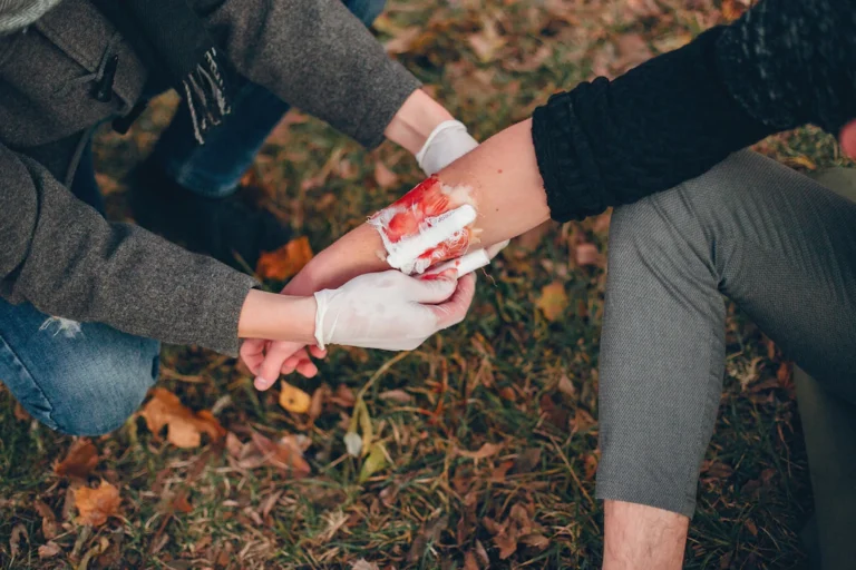 providing-first-aid-park-man-bandaged-injured-arm-guy-helps-friend_1157-40401